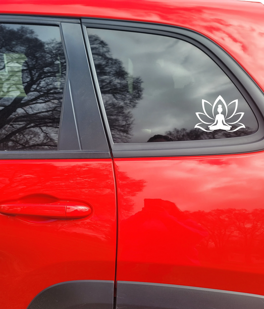 White lotus flower decal with a person meditating on a red car window.