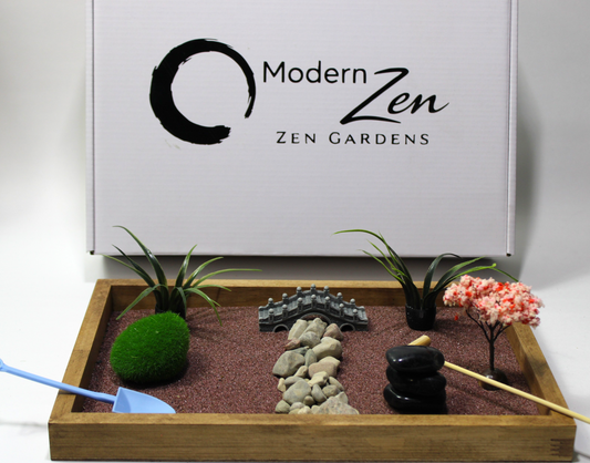 Zen garden kit with rocks, plants, and a rake in front of a 'Modern Zen' box.