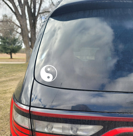 Car window with a white yin yang symbol 